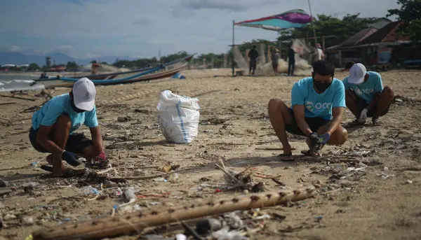 personas en el mar recogiendo basura