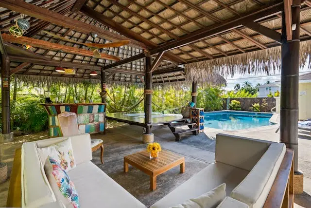 muebles debajo de pergola con una piscina