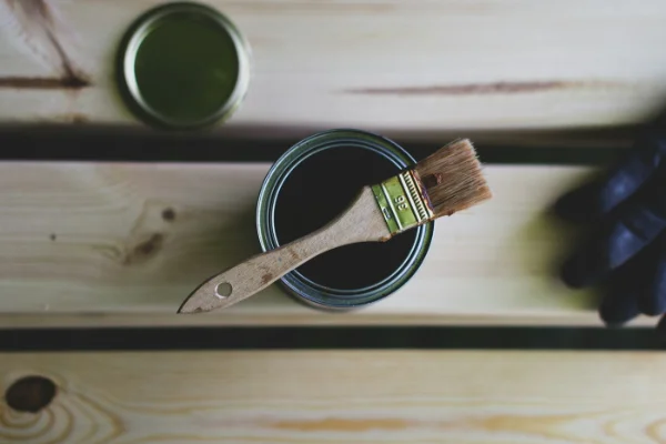 Lata de barniz para madera con una brocha encima